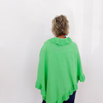 Person wearing a green poncho against a white background