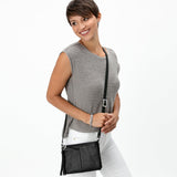 Black leather crossbody bag with a heart-shaped clasp and tassel on a white background
