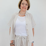 Woman wearing a light-colored outfit with a white background