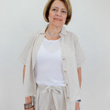 Woman wearing a light-colored outfit with a white background