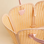 Woven handbag with pink accents on a light beige background