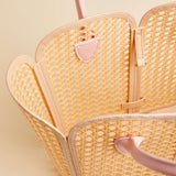 Woven handbag with pink accents on a light beige background