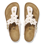 Pair of sandals with white floral straps on a white background