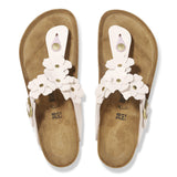 Pair of sandals with white floral straps on a white background