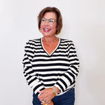 Woman wearing a black and white Karen Kane striped top against a plain background