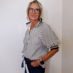 Woman wearing a black and white striped shirt with a plain background
