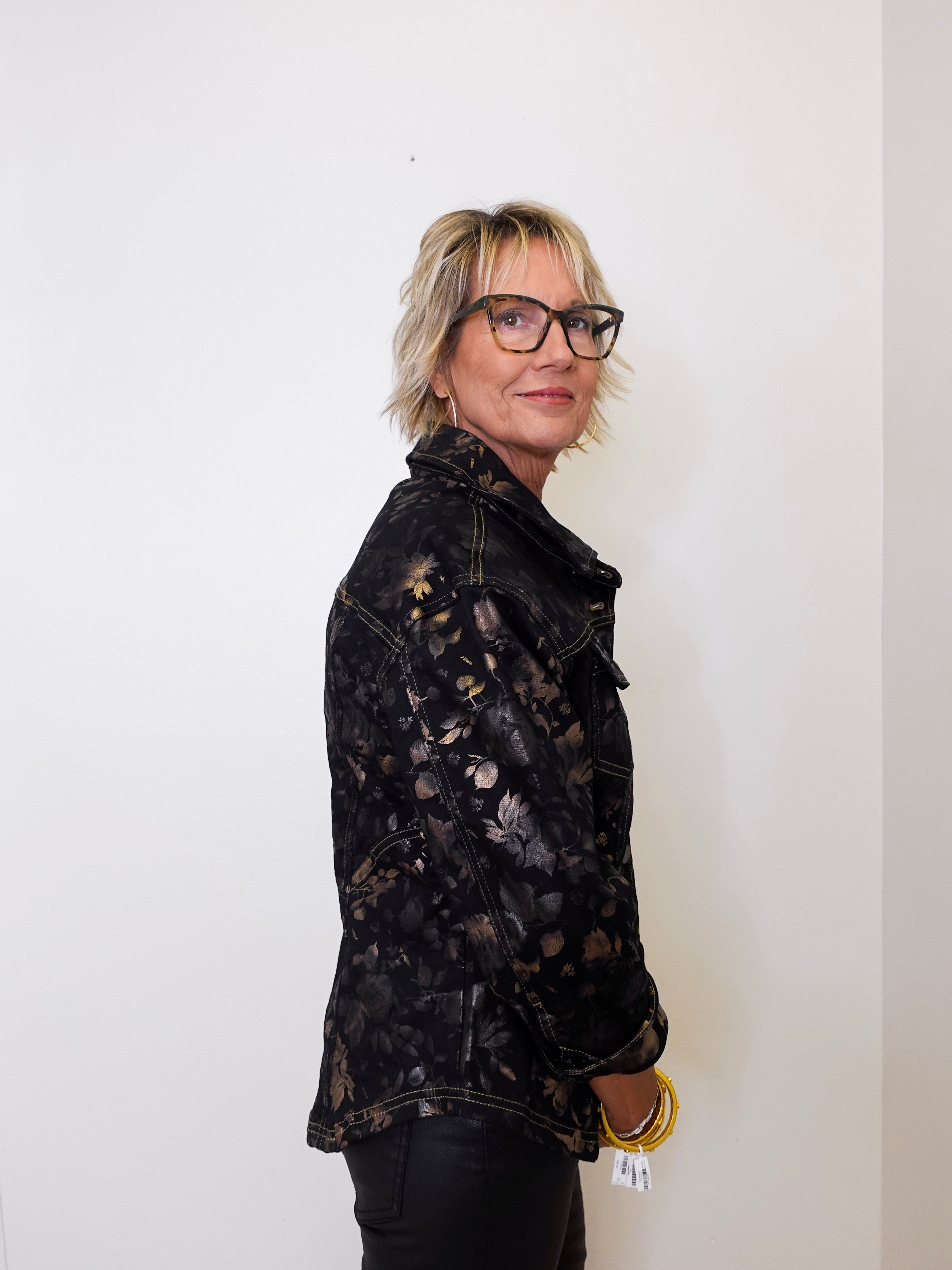 Person wearing a black tie-dye jacket against a white background