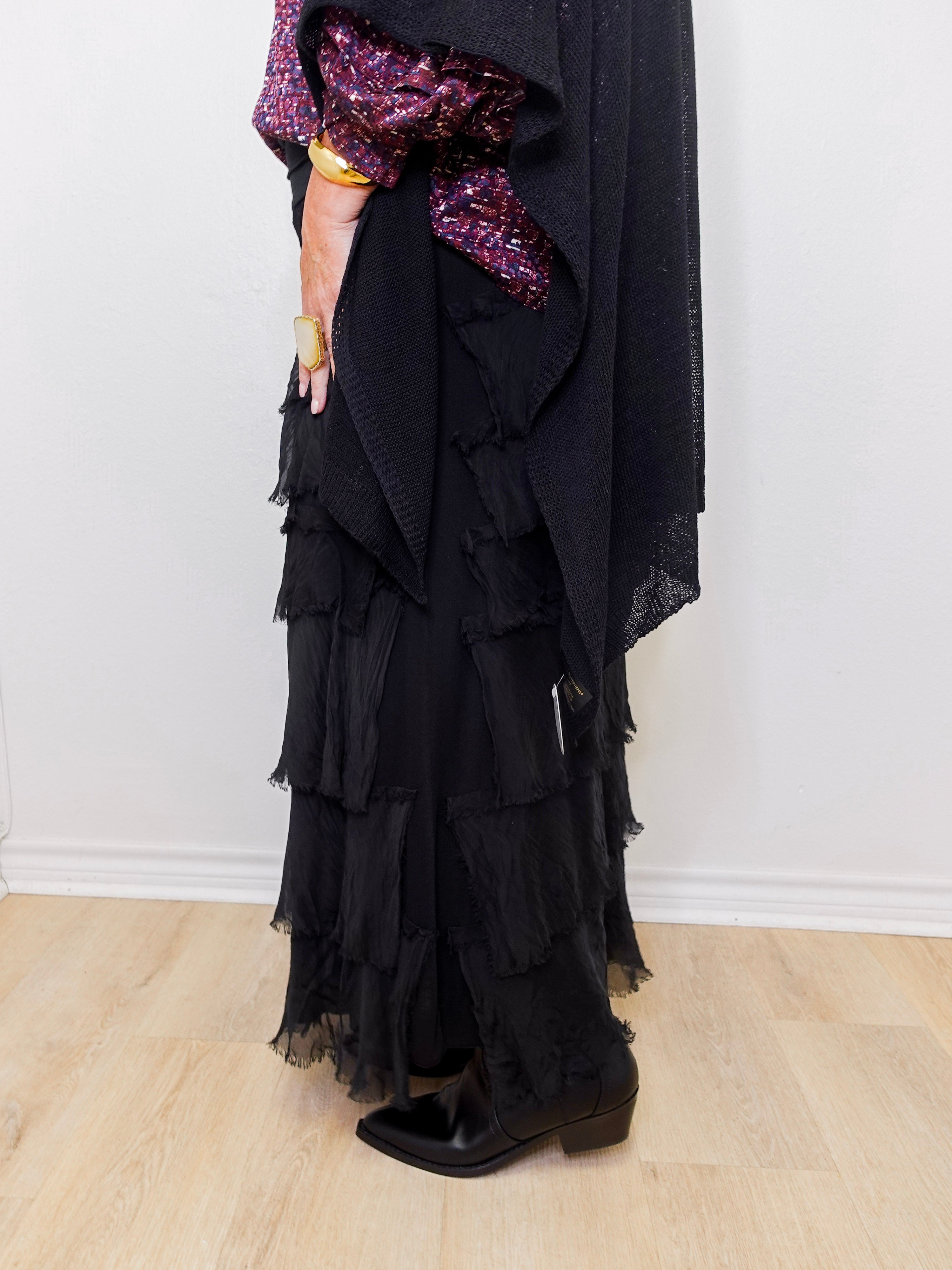 Black ruffled dress with purple sequin sleeves against a white background