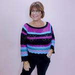 Woman wearing a colorful striped sweater against a plain background