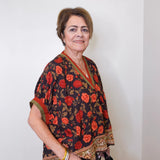women wearing a black floral short sleeve top in front of a white background 