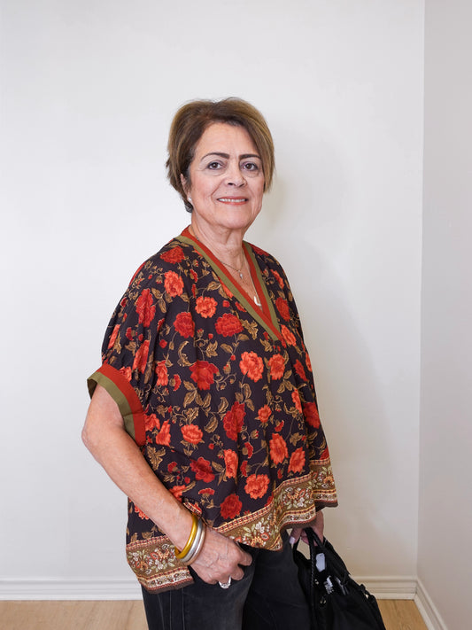 women wearing a black floral short sleeve top in front of a white background 