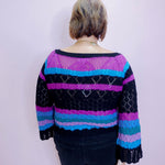 Person wearing a colorful striped sweater against a plain background