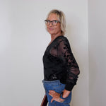 Black 2-piece mesh cardigan and tank set paired with blue jeans, modeled by a woman holding a maroon handbag.
