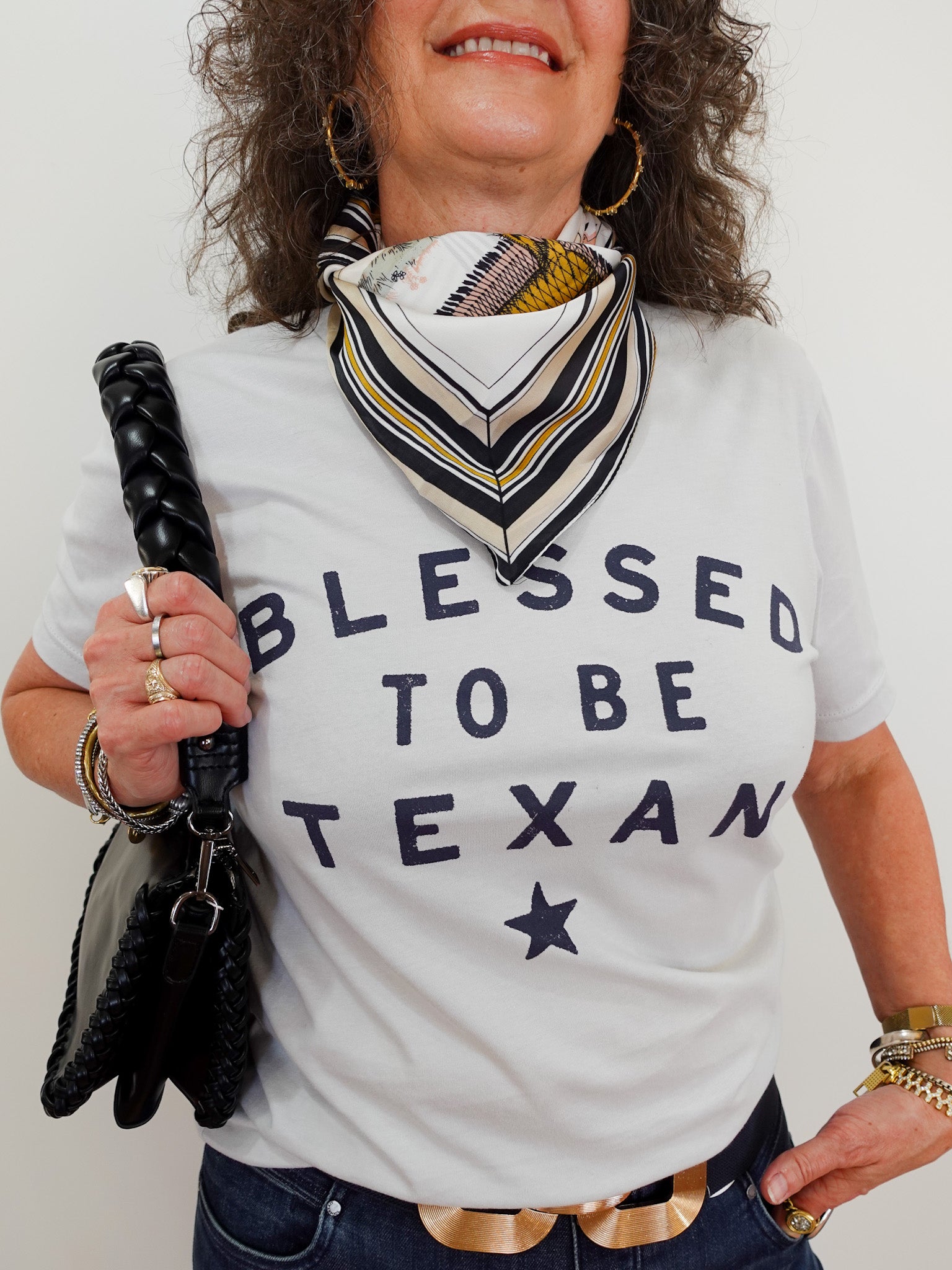Person wearing a 'Blessed to be Texan' t-shirt with a scarf and umbrella.