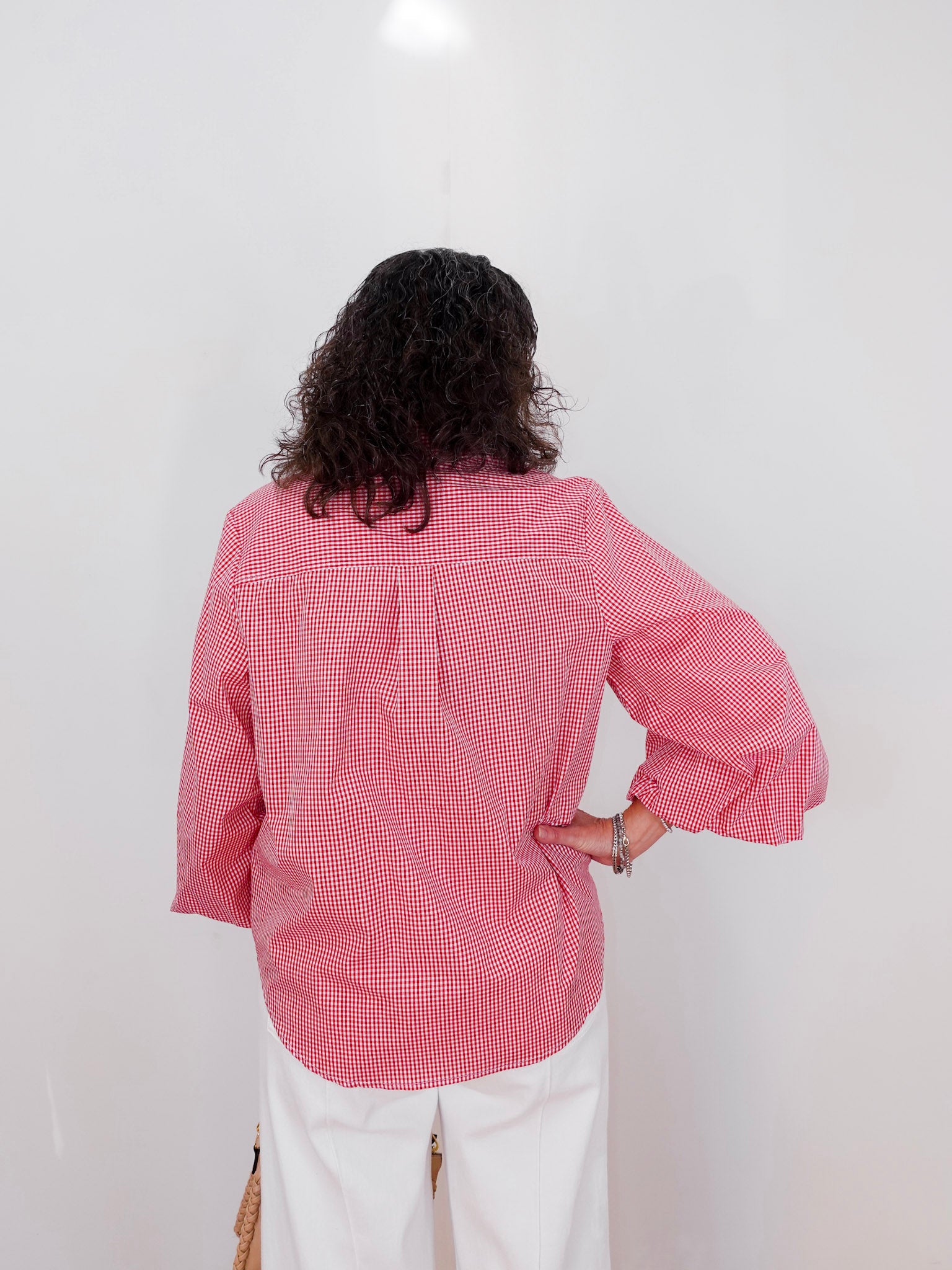 Person wearing a red checkered shirt against a white background