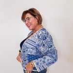 Woman wearing a blue and white patterned jacket against a plain background