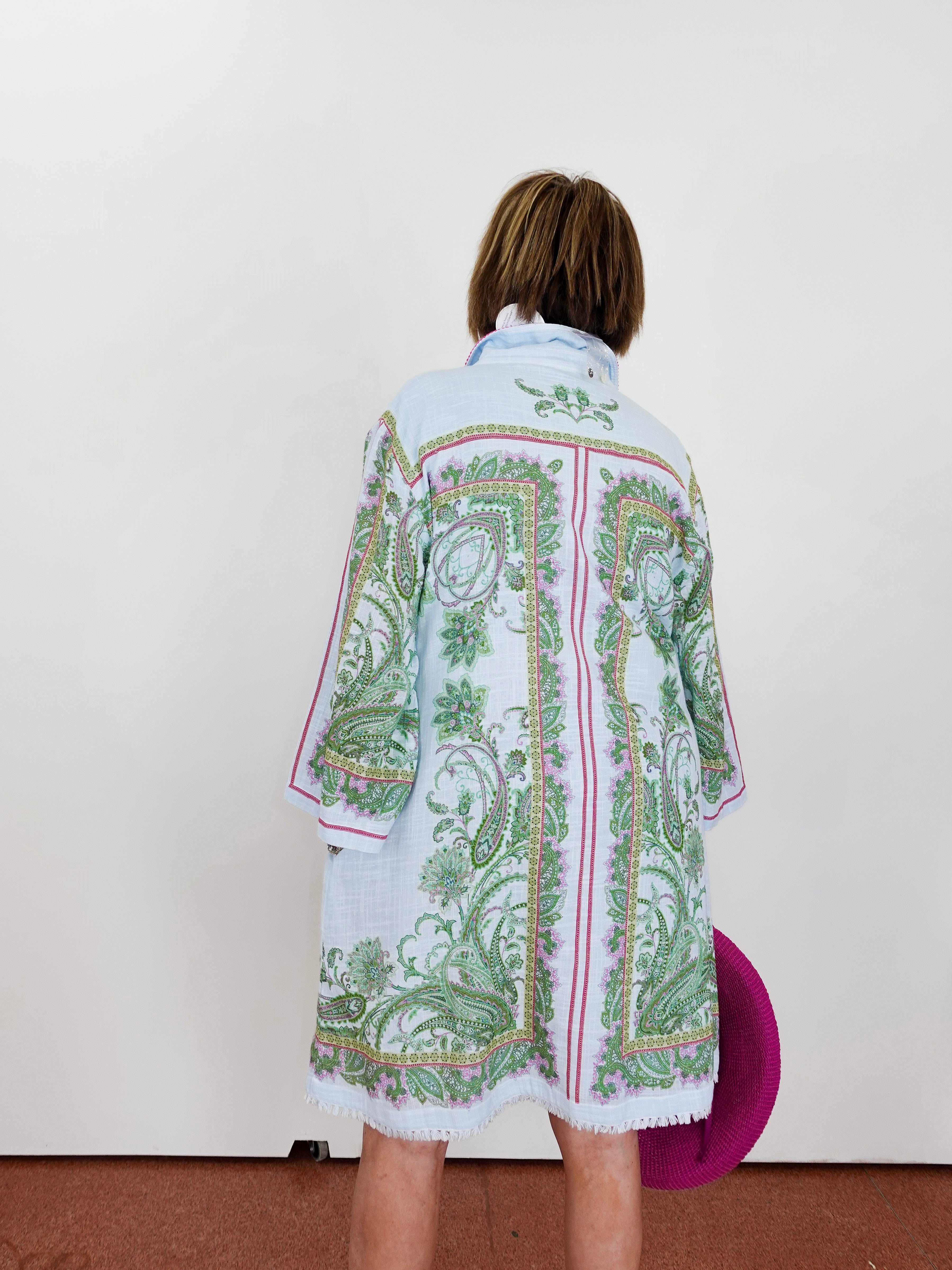 Person wearing a patterned shirt with a plain background