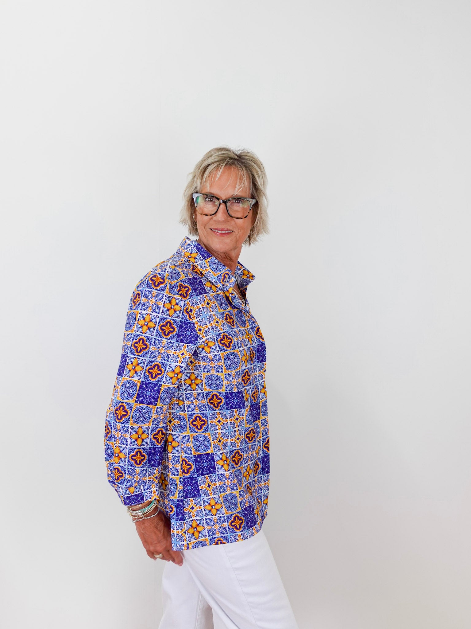 Person wearing a colorful patterned shirt against a white background