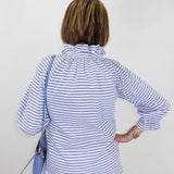 Person wearing a blue and white striped shirt with a white background