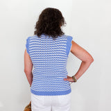 Woman wearing a blue and white striped sleeveless top against a white background
