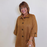 Woman wearing a brown coat against a white background
