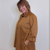 Woman wearing a brown coat against a white background