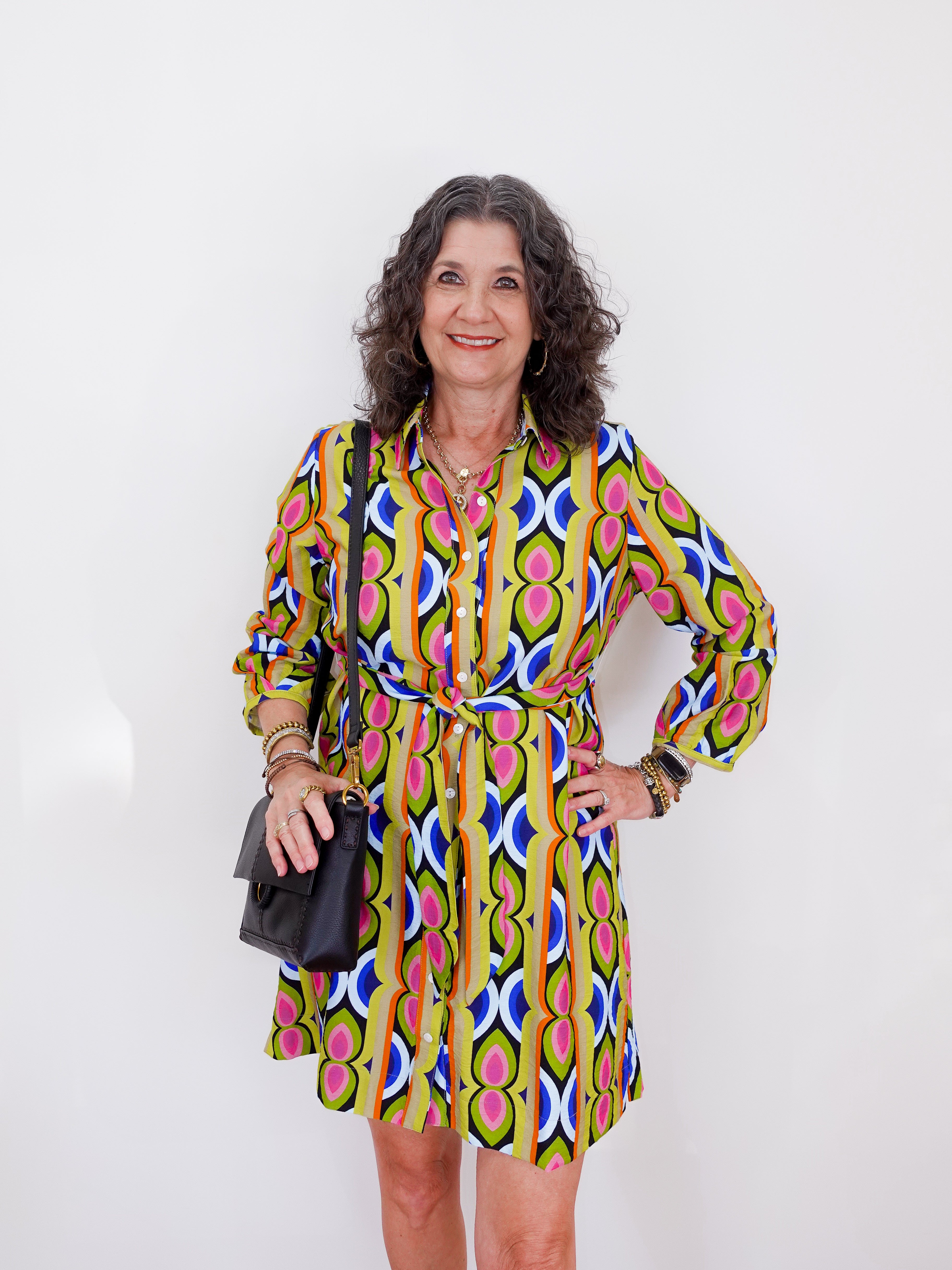 Woman wearing a colorful patterned dress against a white background
