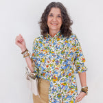 Woman wearing a colorful floral shirt against a white background