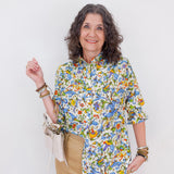 Woman wearing a colorful floral shirt against a white background