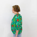 Person wearing a green floral blouse against a white background