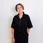 Woman wearing a black dress with a zipper against a white background