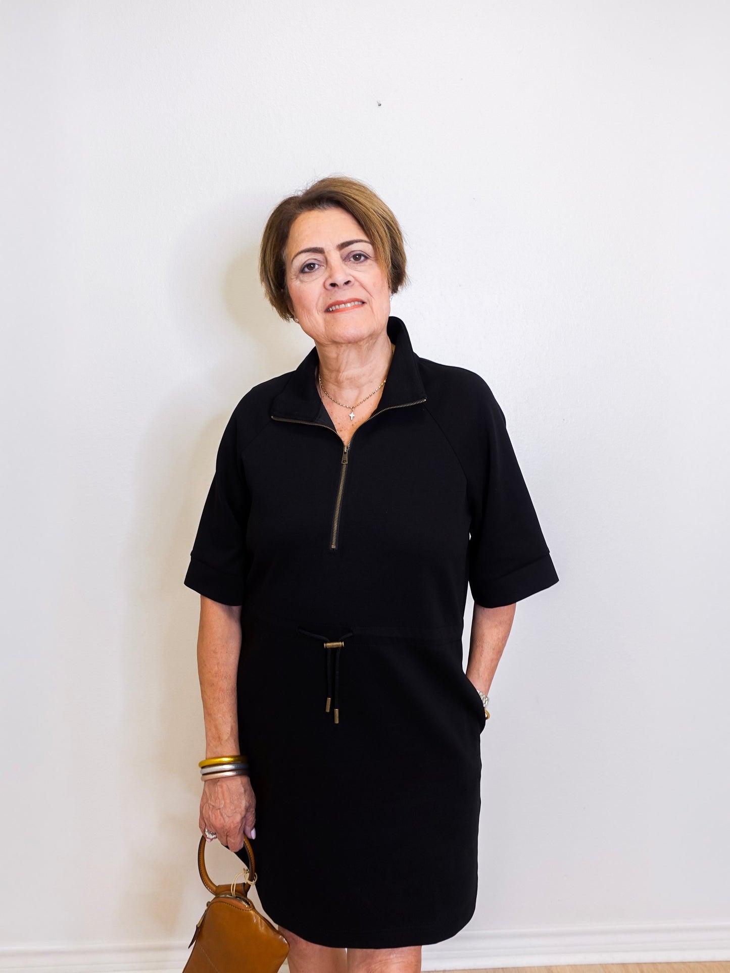 Woman wearing a black dress with a zipper against a white background