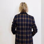 Person wearing a plaid jacket against a white background