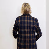 Person wearing a plaid jacket against a white background