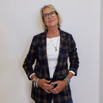 Woman wearing a plaid blazer over a white shirt with a plain background