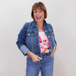 Woman wearing a denim jacket and jeans with a white background