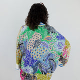 Person wearing a colorful patterned jacket on a plain background