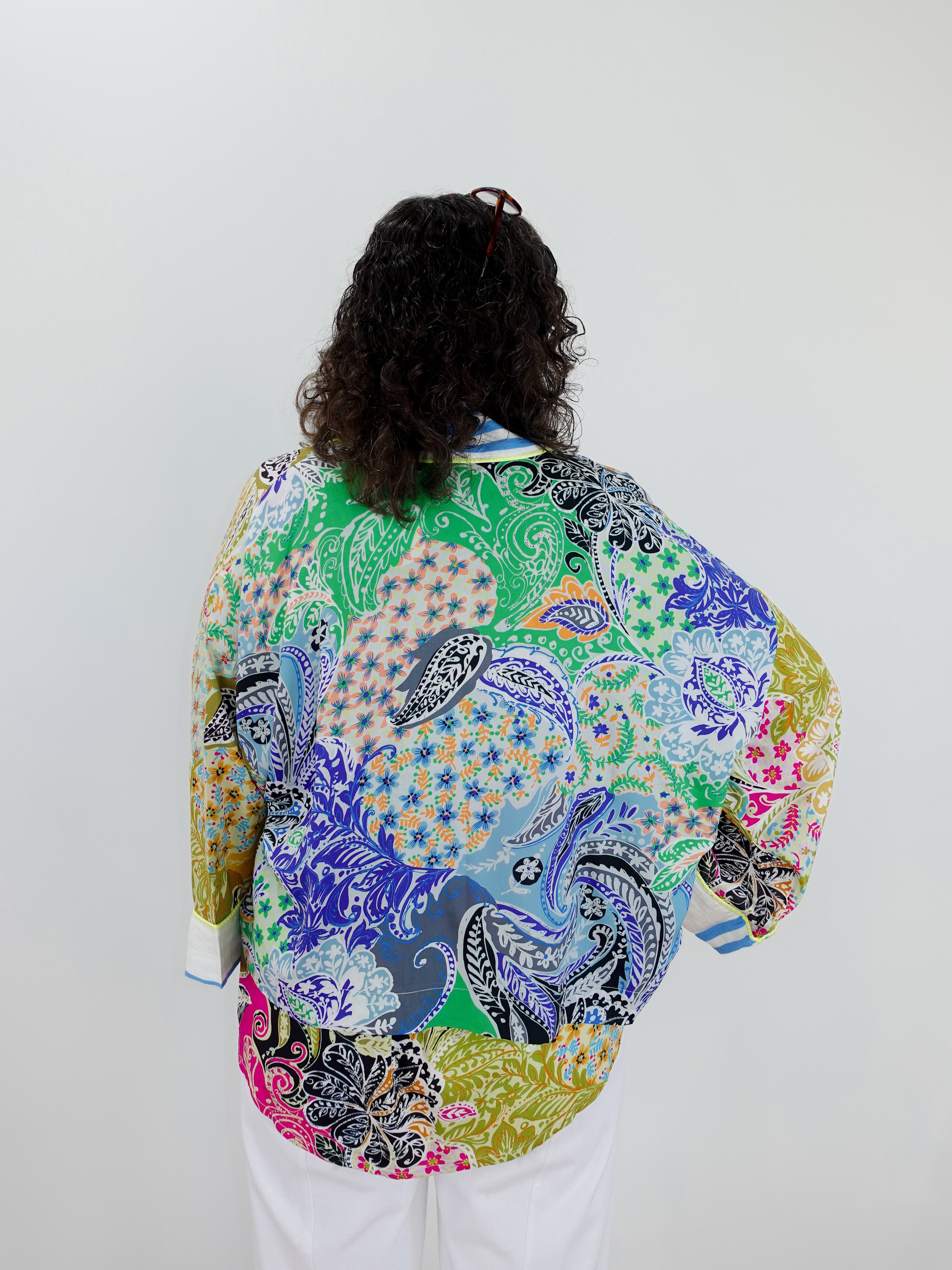 Person wearing a colorful patterned jacket on a plain background