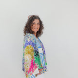Woman wearing a colorful patterned shirt against a white background