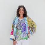 Woman wearing a colorful patterned jacket against a white background
