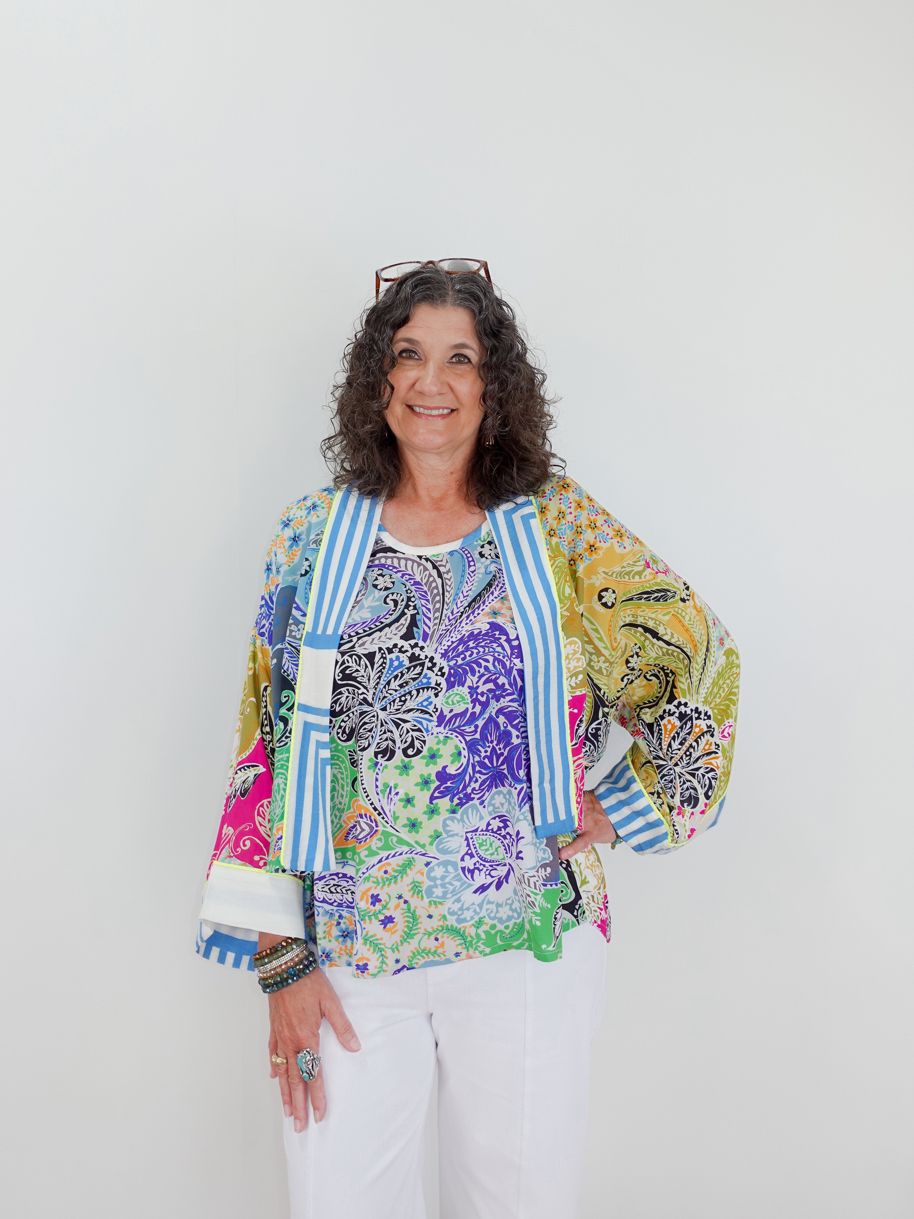 Woman wearing a colorful patterned jacket against a white background