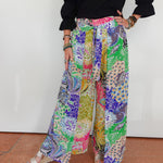 Person wearing colorful patterned pants with a plain background