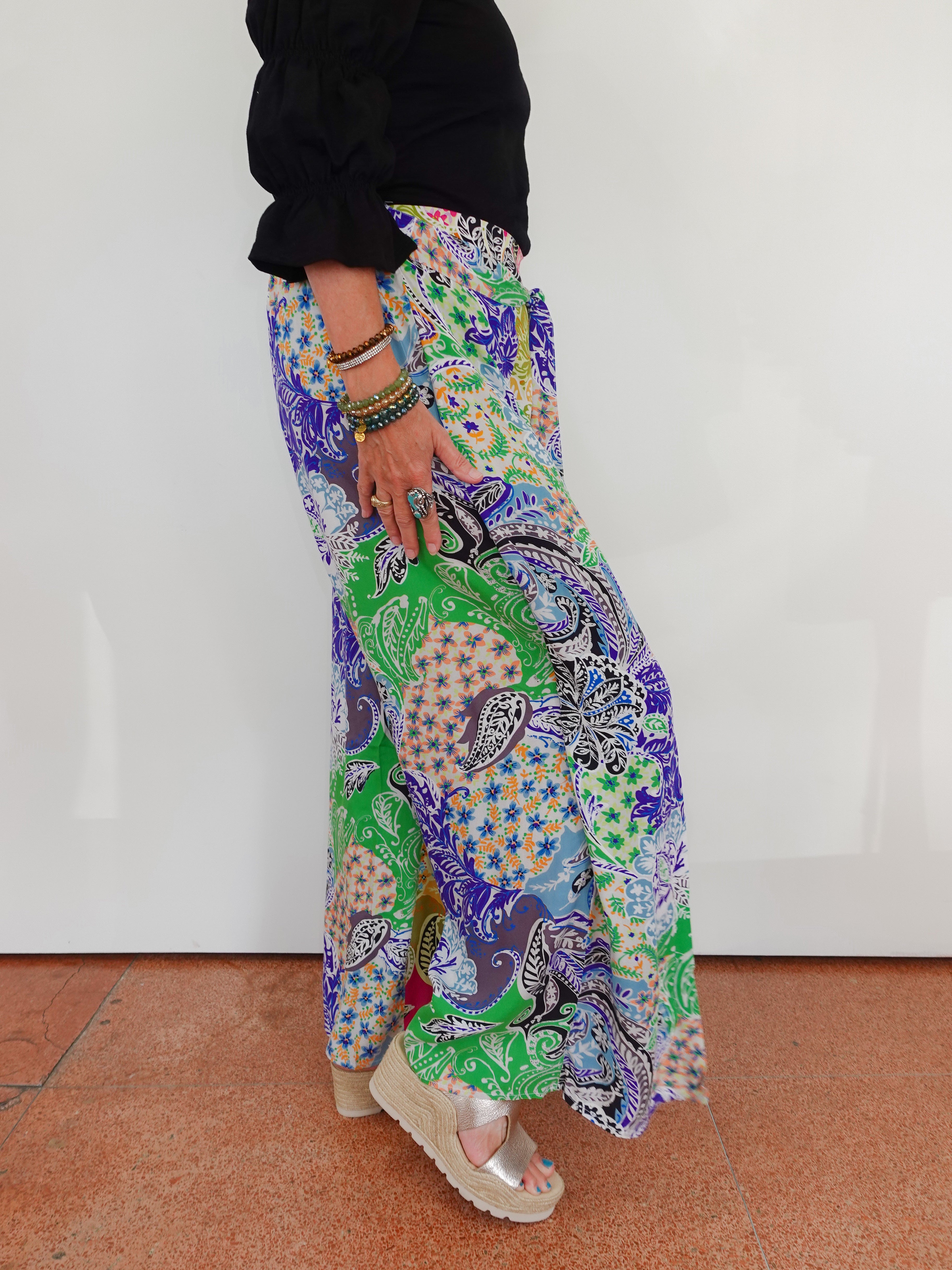 Person wearing colorful patterned pants with a plain background
