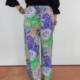Multicolored patterned pants worn by a person on a white background