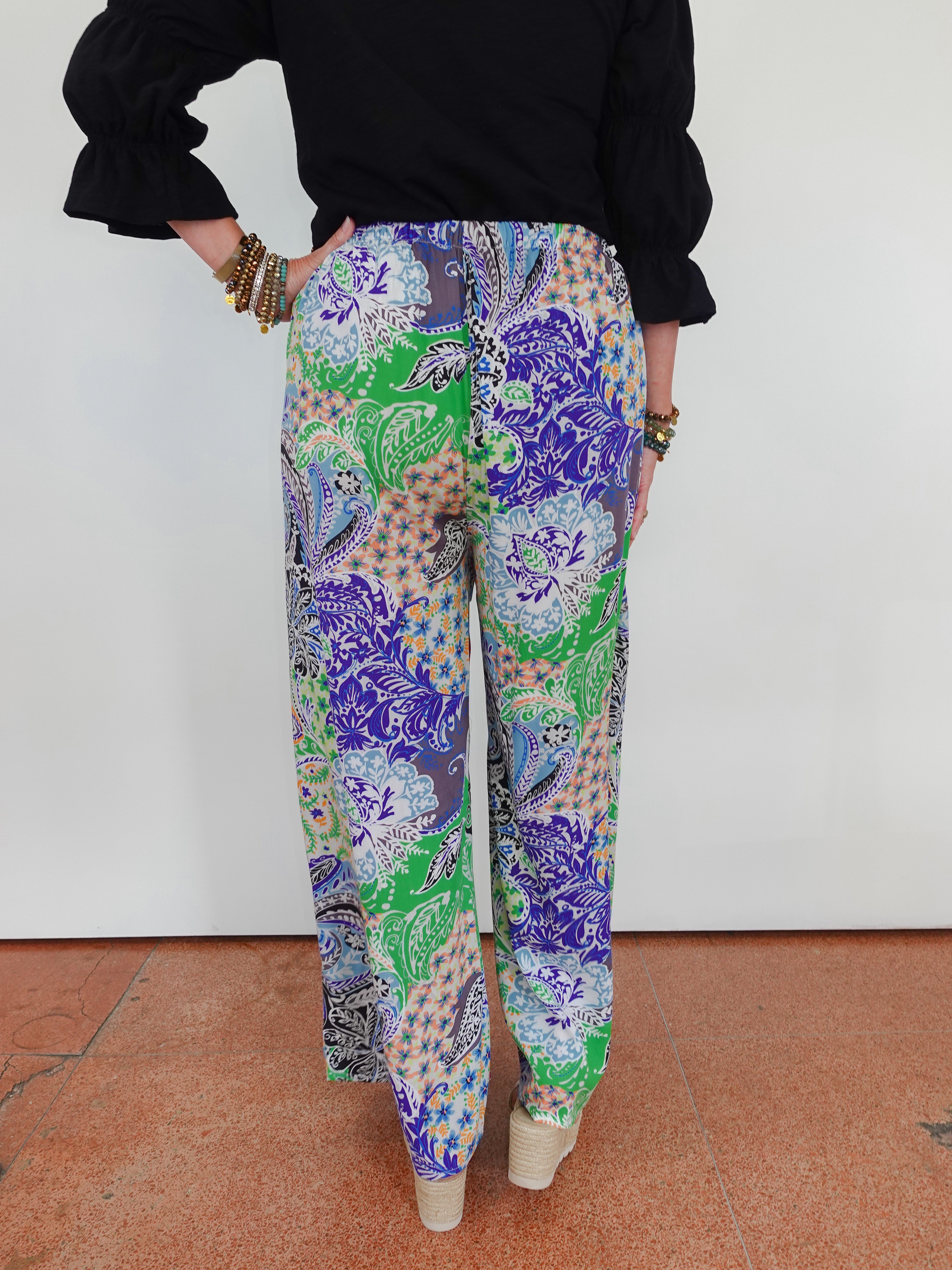 Multicolored patterned pants worn by a person on a white background