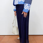 White textured blouse styled with a navy silk foldover waist skirt and blue patterned jacket.