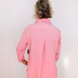 Person wearing a pink jacket against a white background