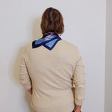 woman wearing a tan waffle knit blouse against a white background. 