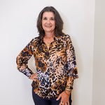 Woman wearing a leopard print blouse against a white background