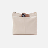 Beige leather bag with a pocket holding a phone on a white background